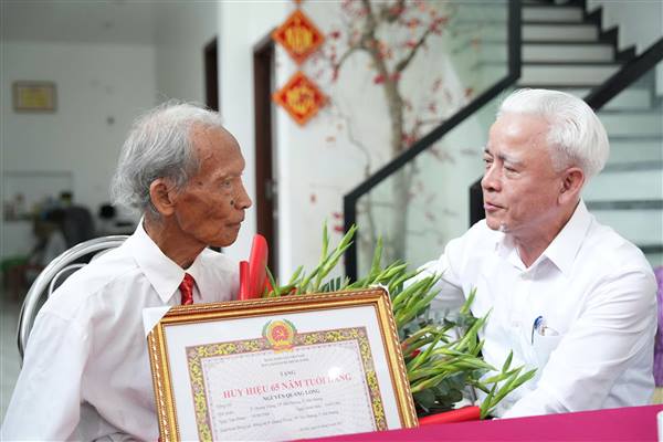 Trưởng Ban Nội chính Thành uỷ Nguyễn Đình Chuyến trao Huy hiệu Đảng cho đảng viên lão thành tại phường Hải Dương