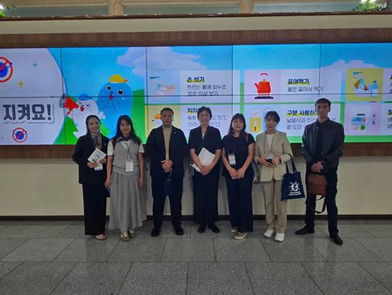 A group of people standing in front of a large screen
AI-generated content may be incorrect.