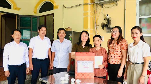 Đồng chí Ngô Thị Thanh Thuỷ, Bí thư Đảng uỷ xã thăm, tặng quà mẹ Việt Nam anh hùng Nguyễn Thị Nuôi