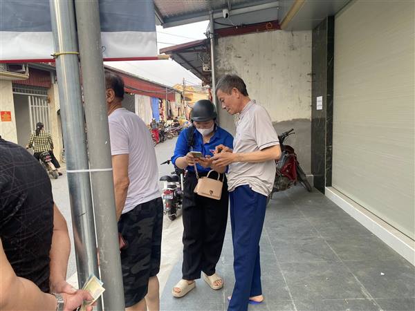 Tổ công nghệ số cộng đồng vượt nắng, thắng mưa hỗ trợ người dân cài đặt sổ tay sức khoẻ điện tử 