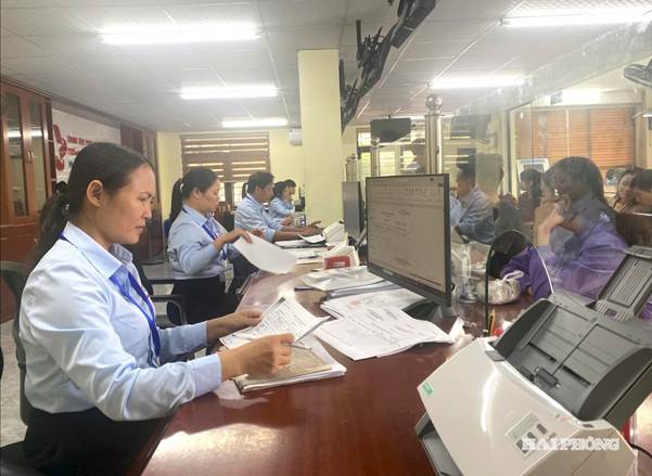 Theo dự thảo nghị quyết, nguồn kinh phí hỗ trợ được bố trí từ ngân sách địa phương theo phân cấp. Trong ảnh: Công chức giải quyết thủ tục hành chính cho người dân tại Trung tâm Phục vụ hành chính công phường Nhị Chiểu.