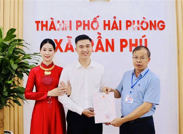 Đôi bạn trẻ Nguyễn Thành Trung và Trần Thị Thùy Giang phấn khởi khi được lãnh đạo UBND xã Trần Phú trao Giấy chứng nhận kết hôn