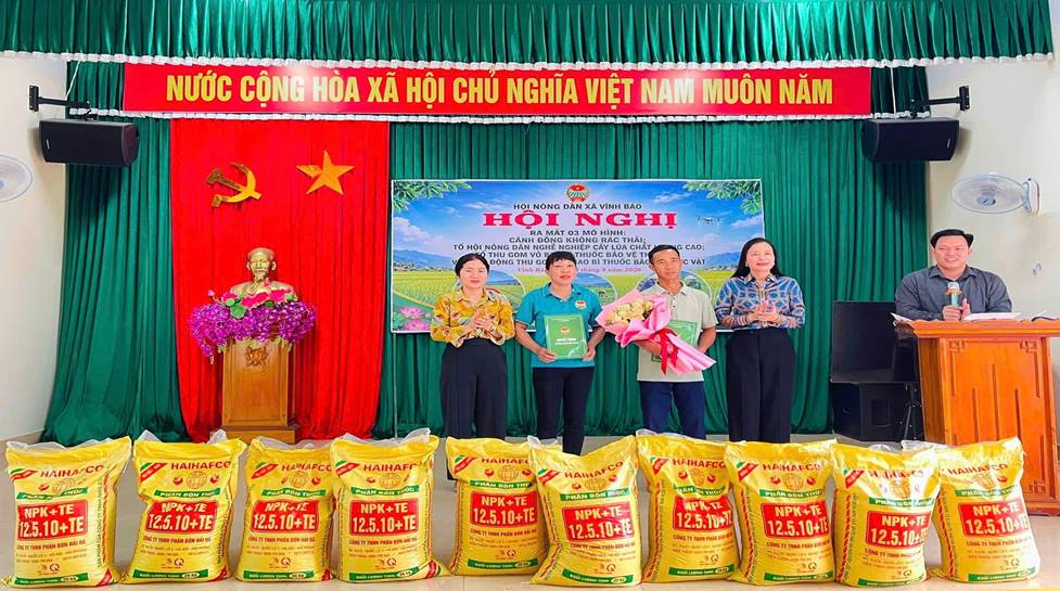 A group of people standing in front of a stage with bags of food
Description automatically generated