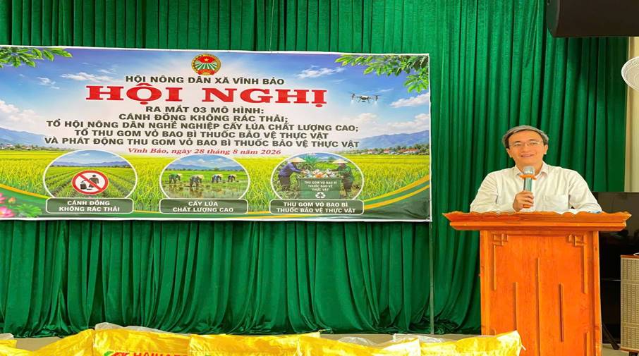 A person standing at a podium with a microphone in front of a green curtain
Description automatically generated